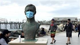根據約翰霍普金斯大學和冠狀病毒疾病追蹤計畫統計數據，加州成為全美首個確診數突破300萬大關的州。圖為加州芮當多海灘傳奇救生員佛利斯雕像被戴上口罩，與周圍不戴口罩的遊客形成對比。（中央社檔案照片）