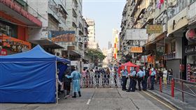 香港佐敦道封區　當地居民須接受強制檢測香港鬧區佐敦一帶近期不斷有確診者，港府23日清晨4時起進行部分封區。圖為佐敦南京街，沿途大樓已被封鎖，由身著防護衣的防疫人員前往進行檢測。中央社　110年1月23日