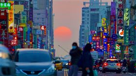 高雄懸日又來了（1）高雄市青年路「懸日」美景28日傍晚再度現身，橘澄澄的太陽緩緩落下，以車水馬龍的街道與五光十色的招牌為襯，格外吸睛，也吸引許多攝影愛好者前往搶拍。中央社記者董俊志攝　110年1月28日