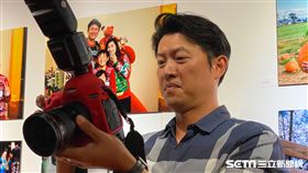 王建民拿起相機拍攝現場嘉賓和記者。（圖／記者王怡翔攝影）