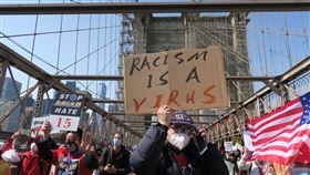紐約萬人遊行  示威者舉反種族歧視標語2019冠狀病毒疾病期間仇恨犯罪盛行，紐約上萬民眾當地時間4日遊行呼籲停止仇恨亞裔，示威者在布魯克林大橋上高舉「種族歧視是病毒」標語。中央社記者尹俊傑紐約攝  110年4月5日