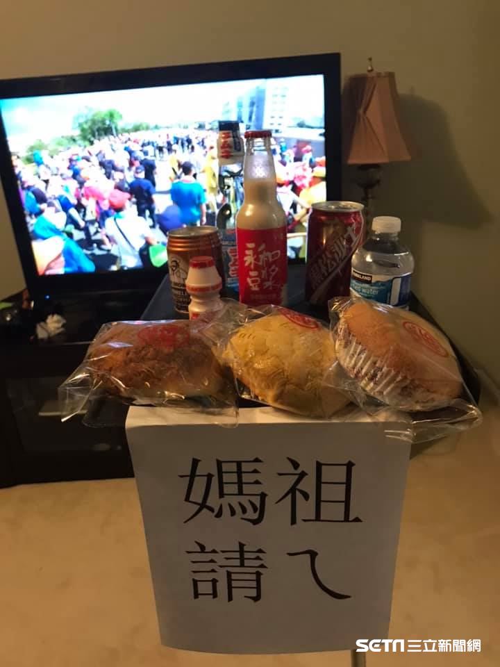 「遠端進香」儀式感也要拉滿！Mike誠意十足地準備了「神明供品桌」，還幽默貼上「媽祖請的」告示，彷彿連白沙屯的現場香氣都飄進了美國客廳。（資料照／Mike Chuang授權提供）
