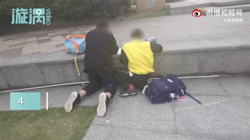 2小學生跪在路邊趕作業　哀怨這麼說