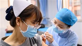 中國防疫專家鍾南山今天說，中國當前正全力研發針對變異毒株的疫苗。圖為1月山西太原社區衛生中心工作人員接種疫苗。（圖／中新社）
