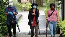 民眾外出散步戴口罩防疫本土武漢肺炎疫情嚴峻，全國疫情警戒第3級延長至28日，有民眾9日外出散步除了戴上口罩，也戴上手套做更周全的防疫保護。中央社記者鄭傑文攝　110年6月9日