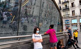 西班牙街頭人們戴著口罩，不過從本月26日開始在戶外將不再強制戴口罩了。（圖／美聯社／達志影像）