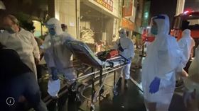 ▲彰化喬友大樓火警，有3層樓是防疫旅館，24名隔離中的民眾正被一一疏散下樓，一下樓就穿上防護衣，由救護人員送上救護車直奔新的防疫旅館。（圖／翻攝畫面）