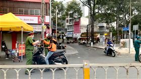 胡志明市市民對如期解封沒把握胡志明市全市9日起實施為期15天的社交距離措施，民眾除非必要否則都得待在家。圖為胡志明市警方12日在路上攔查民眾、檢查外出文件。（讀者提供）中央社記者陳家倫河內傳真  110年7月12日