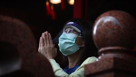 疫情嚴峻　民眾廟宇前參拜祈福國內武漢肺炎（2019冠狀病毒疾病，COVID-19）疫情延燒，一位民眾戴著口罩和面罩到廟宇前，雙手合十參拜祈福。中央社記者王騰毅攝　110年6月9日