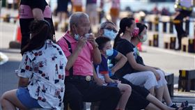 指揮中心宣布戶外飲食新指引（1）中央流行疫情指揮中心指揮官陳時中17日下午在疫情記者會中表示，目前全國仍處於COVID-19（2019冠狀病毒疾病）3級警戒期間，民眾外出一律須戴口罩；若在戶外有飲食需求，需在室外通風處並保持社交距離才可飲食。圖為民眾17日在八里老街一帶休憩飲食。中央社記者徐肇昌攝  110年7月17日