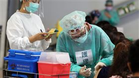 北市國小教職員接種疫苗（3）因應COVID-19疫情，台北市政府20日安排國小教職員工（含特教學校及實驗教育等）在花博大型接種站施打疫苗。醫護人員細心為民眾施打疫苗。中央社記者郭日曉攝  110年7月20日