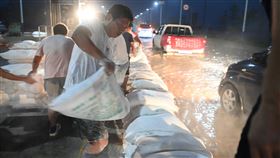 河南暴雨  新鄉民眾加強築堤河南連日大暴雨，23日，衛河河南新鄉段等部分河段出現險情。當日夜間，當地村民在G107國道新鄉段壘築堤壩抵禦洪水。（中新社提供）中央社  110年7月24日