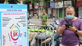 越南COVID-19疫情持續升溫越南27日新增7911例COVID-19本土病例，連續5天單日新增確診數都超過7000人。圖為戴著口罩的越南民眾與防疫宣導招牌。中央社記者陳家倫河內攝  110年7月27日