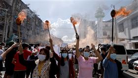 緬甸在軍人奪權後，疫情迅速惡化，圖為當地婦女舉起火炬抗疫軍事政權。（圖／路透社／達志影像）