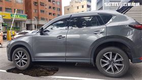 台中市忠明南路也出現天坑，導致休旅車左前輪陷落。（圖／翻攝畫面）