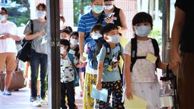 小學開學日　新生戴口罩報到高中以下學校31日開學，校園配合防疫政策，實施量體溫、酒精手部消毒等防疫措施，多數學生也主動戴上口罩上學。圖為台北市文湖國小新生戴口罩排隊報到。中央社記者王飛華攝　109年8月31日