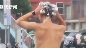 男騎士等紅燈時突然下起大雨，下一秒竟拿出洗髮精，在馬路上洗頭。（圖／翻攝自荔枝新聞） 