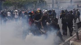 泰國抗議民眾試圖蓋住催淚彈煙霧泰國民眾13日上街抗議，要求總理帕拉育下台，警方以催淚彈驅離抗議民眾，圖為民眾嘗試蓋住催淚彈煙霧。中央社記者呂欣憓曼谷攝  110年8月13日