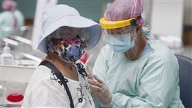 民眾施打COVID-19疫苗（2）日本、美國捐贈的武漢肺炎疫苗374萬劑到貨，中央流行疫情指揮中心擴大接種對象從7類到10類，最新公費施打順位納入18萬名孕婦，65歲以上長者在下一波名單上，也打得到。民眾22日穿戴防疫裝備在台灣科學教育館大廳施打疫苗。中央社記者徐肇昌攝  110年6月22日