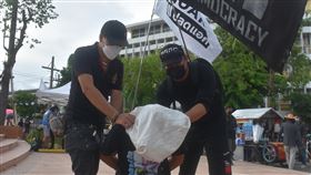 抗議民眾諷刺警察悶死毒販泰國那空沙旺府的警察涉嫌向毒販索賄並將毒販悶死，影片流出引起泰國輿論譁然。圖為泰國民眾25日在一場反政府抗議中以行動劇方式諷刺泰國警察。中央社記者呂欣憓曼谷攝  110年8月26日