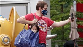 新增9例本土  幼兒園8童、1家長確診中央流行疫情指揮中心宣布，6日新增9例本土個案，皆與新北市某幼兒園確診老師有關，包括8名學童及1名家長。圖為一名家長用購物袋背著幼童拍照。中央社記者鄭傑文攝  110年9月6日