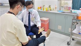楊維宏醫師替患者檢查扭傷處，並說明足踝骨位置區分。示意圖。（圖／台中醫院提供）