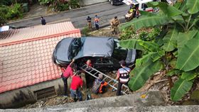 ▲台南市楠西區1棟民宅屋頂突然傳出巨響，路過民眾一看，竟然是一輛轎車應卡在屋頂上，車內還有人呼救。消防隊到場後，陸續救出車內4人，所幸沒有大礙，不排除因為不熟路況，過彎時不慎失控下衝導致。（圖／翻攝畫面）