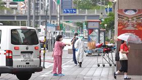疫情嚴峻　救護車安全護送病患至醫院武漢肺炎（2019冠狀病毒疾病，COVID-19）疫情嚴峻，29日台北市一處防疫旅館，病患在醫護人員安全護送下，自防疫旅館內移出，由救護車送往醫院。中央社記者王飛華攝  110年5月29日