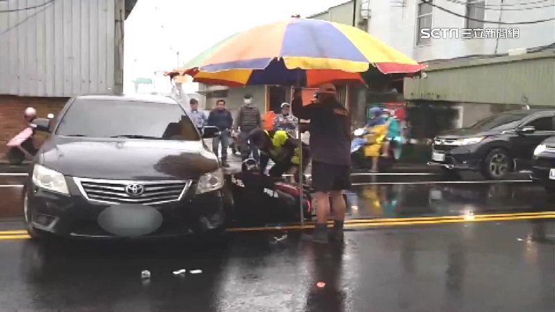 違規迴轉捲騎士　工人大傘幫擋雨待救