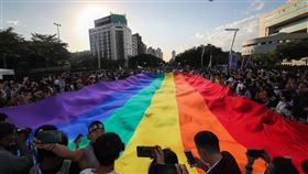 台灣同志遊行　13萬人街頭相挺（1）2020第18屆台灣同志遊行31日在台北盛大登場，主辦單位表示，今年有13萬人共襄盛舉，也讓台灣同志遊行成為今年度北半球最大的同志遊行。圖為遊行隊伍抵達終點時，人群圍繞在巨型彩虹旗周邊拍照留念。中央社記者裴禛攝　109年10月31日