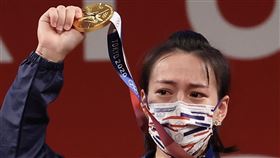 舉起台灣東奧首面金牌　郭婞淳激動紅眼眶（1）來自後山單親家庭的舉重女將郭婞淳憑著雙手，為自己和台灣體壇撐起一片天，長滿厚繭的雙手，幫她翻轉了世界，27日在東京奧運女子舉重59公斤級拿下的這面金牌，也讓世界看到台灣。圖為郭婞淳在頒獎台上高舉金牌，一度紅了眼眶。中央社記者吳家昇攝  110年7月27日