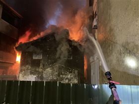 ▲台南市府前一路一棟2層樓透天老房子被濃煙包圍，火舌從窗戶竄出，相當驚險。消防隊救出80歲阿嬤和32歲孫子，2人輕傷送醫。（圖／翻攝畫面）
