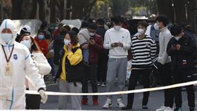 中國特色的時空系防疫 充滿措手不及的驚奇（5）中國社區一旦出現確診者，整座社區便面臨至少14天的管控，居民無法進出。這時，社區居民只能委託外送將物品送往社區出入口的指定地點，集中領取。圖為上海一處被管控的社區居民，一同在管制點等待外送的景像。（中新社提供）中央社記者邱國強北京傳真 110年12月1日