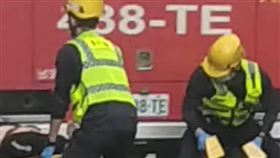 一名男子為了躲避濃煙爬出窗外，在6樓等待救援，未料從高處直接墜落，摔落在停靠路邊的一輛白色轎車車頂，被送往醫院救治。（圖／翻攝畫面）