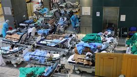 香港醫院病床不足  確診病患難以安置香港疫情延燒，不少醫院每日要接收數百名COVID-19確診病人，由於病床與空間不足，許多人只能暫時在醫院臨時搭建的戶外空間等待。圖為香港明愛醫院一隅。（中通社）中央社  111年3月8日