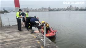 新北市三重區警消在河岸旁打撈起1具男性浮屍。（圖／翻攝畫面）