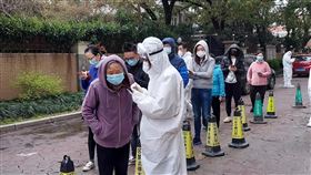 上海大範圍封閉社區  幾乎全員核酸檢測（2）上海市為遏阻COVID-19疫情，15-17日針對重點區域、18-19日針對非重點區域的人群核酸檢測。這些街鎮內的居民社區封閉48小時並執行兩輪檢測。圖為一社區居民18日排隊等待核酸檢測，年長者由工作人員協助在網路上登記資料。中央社記者張淑伶上海攝  111年3月20日