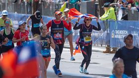 波士頓馬拉松  視障選手周坤芳舉國旗衝線第126屆波士頓馬拉松18日舉行，台灣視障選手周坤芳（7673號）與陪跑員侯美花高舉國旗衝向終點線。（駐波士頓辦事處提供）中央社記者尹俊傑紐約傳真  111年4月20日