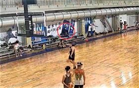 ▲寸姓男子長相酷似歌手楊宗緯，卻四處行竊。42歲寸男(紅圈處)坐在球場邊，趁沒人注意，伸手進民眾的包包裡偷錢。（圖／翻攝畫面，下同）