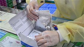 快篩實名制上路  民眾赴藥局購買情形（2）家用快篩試劑販售實名制28日上路，以身分證字號尾數單雙號進行分流。圖為新北市板橋區欣民藥局，藥師打開快篩劑包裝盒供民眾核對數量。中央社記者趙世勳攝  111年4月28日