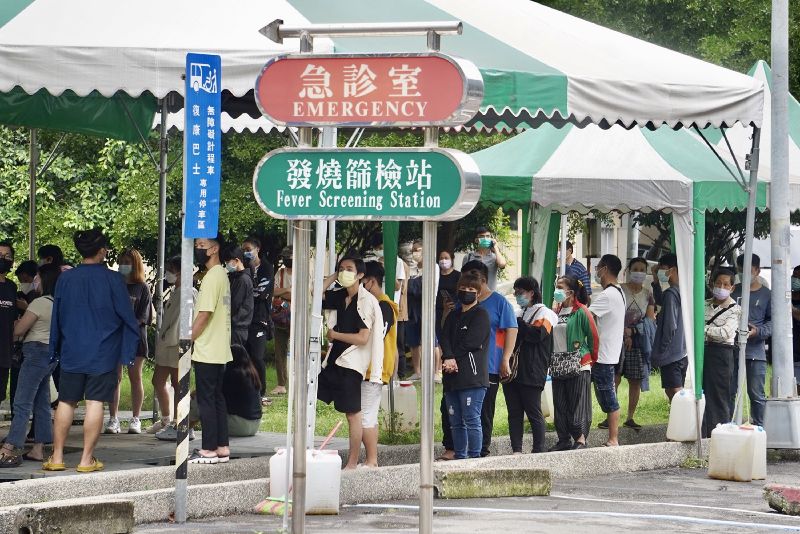 疫情未歇,高雄市苓雅區的社區篩檢站23日有不少民眾前往排隊等待採檢。(圖/中央社)