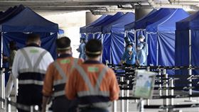 香港機場國泰貴賓室女員工確診香港衛生當局17日通報新增一例COVID-19本土確診，是國泰航空機場貴賓室女員工，研判她是遭到轉機旅客感染。圖為香港機場人員今天在機場流動採樣站接受強制檢測。（中通社提供）中央社　110年8月17日