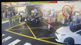 ▲張男在基隆廟口夜市不滿被「瞄一下」，持剪刀刺傷潤餅攤陳姓老闆，一旁家人趕緊制止(紅圈處)。（圖／翻攝畫面）
