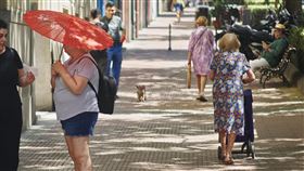 馬德里街頭撐傘的民眾本無撐傘遮陽習俗的西班牙人，經過今夏嚴酷熱浪洗禮後，也開始學起亞洲遊客，打起傘來遮陽。中央社記者胡家綺馬德里攝  111年7月21日