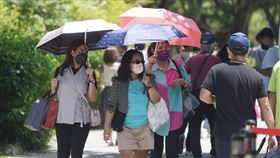 8/7本土增2萬1771例（2）中央流行疫情指揮中心宣布，7日新增2萬1771例COVID-19（2019冠狀病毒疾病）本土病例，確診個案增中重症87例，其中42人死亡。圖為民眾在大安森林公園撐傘遮艷陽。中央社記者徐肇昌攝　111年8月7日