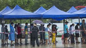 中國官方公布，9日新增952例COVID-19本土病例，海南病例占約6成。圖為9日海南瓊海市民排隊做核酸檢測。（圖／中新社）
