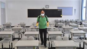 北京中小學及幼兒園開學在即，校園需採封閉管理。圖為2021年8月北京匯文中學工作人員在教室內進行消毒作業。（圖／中新社）
