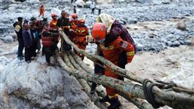 中國四川瀘定縣5日發生規模6.8地震，搜救員背負傷者過河。（圖／中新社）
