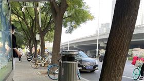 北京四通橋事件現場高度戒備  黑衣人四處盯梢北京市四通橋13日發生民眾掛布條抗議事件後，周邊街道14日進入高度戒備狀態，來往路人成為警察及黑色便衣盯梢的對象。圖為四通橋旁80公尺的一處公車候車亭，倚靠亭柱吐煙、著黑衣帽黑鞋的半身男子，即為盯梢的黑衣人。中央社記者邱國強北京攝  111年10月14日