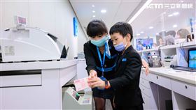 「小富翁理財營」中讓小學員們換上行員制服，並在行員指導下進行「小小行員體驗」，實際演練銀行最基礎的存款、提款、兌換外幣等各式交易，從中理解銀行的運作方式。（圖／北富銀提供）